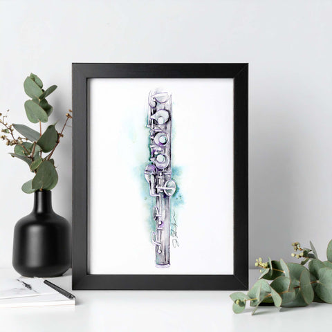 Framed artwork of a stylized flute on a white surface with greenery
