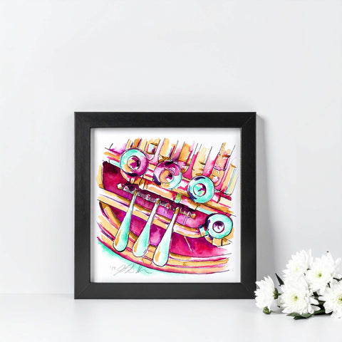 Framed colorful abstract art piece on a white wall with flowers in the corner.