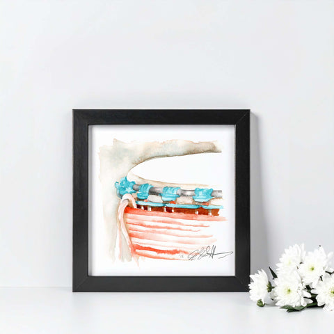 Framed artwork of a drum with turquoise thread on a white background