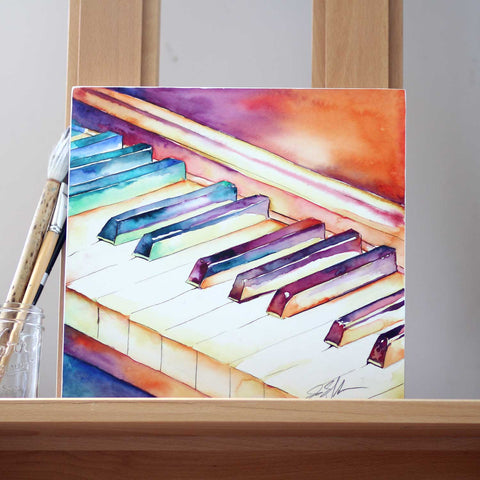 piano watercolor with paintbrushes on easel