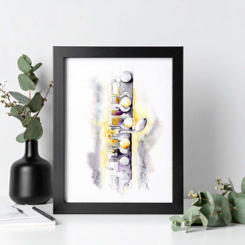 Framed abstract art piece on a white surface with eucalyptus leaves