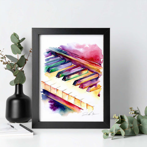 Framed artwork of colorful piano keys on a white surface with decorative elements.