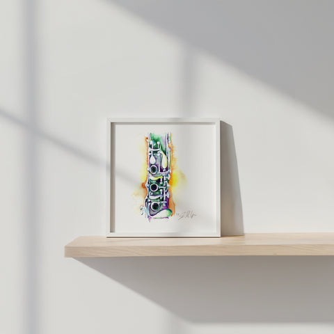 Framed colorful abstract art piece on a wooden shelf against a white wall.