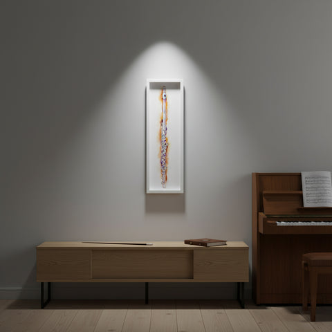 Wooden cabinet with a framed artwork on a gray wall, next to a piano.