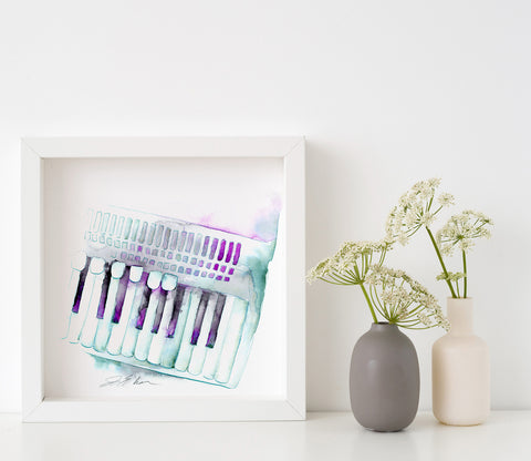 A framed watercolor painting of an accordion with purple, blue, and green colors on a white background, displayed on a shelf next to a plant vase.