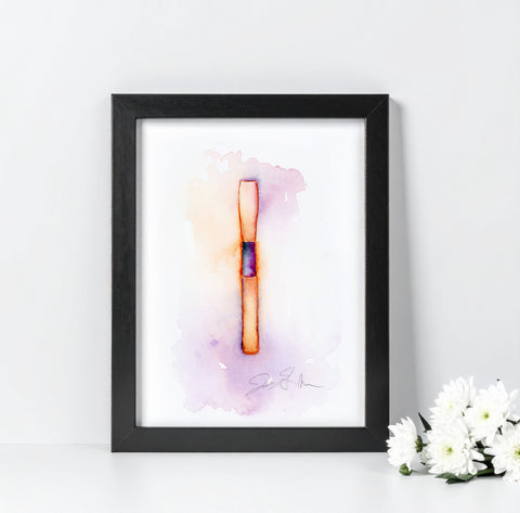 Framed artwork of a colorful abstract reed design on a white wall with flowers to the side.