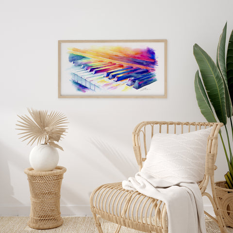 Framed colorful abstract painting on a wall above a wicker chair with a plant and decorative vase.